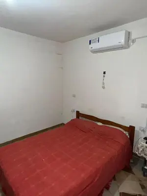 a bedroom with a red bed and a air conditioner at Cabañas Antonia in San Javier