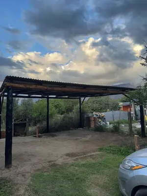 a covered area with a car parked in a yard at Cabañas Antonia in San Javier