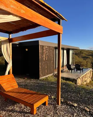 a building with a deck with two chairs on it at Suite del Alba in La Estancia