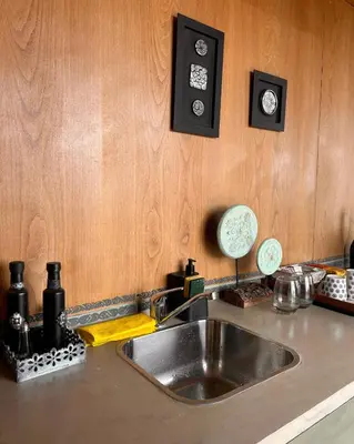 a kitchen counter with a stainless steel sink and wooden walls at Suite del Alba in La Estancia
