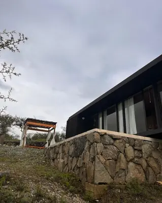 a stone wall next to a black building at Suite del Alba in La Estancia