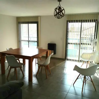 a dining room with a wooden table and chairs at Departamento céntrico amplio in Río Cuarto