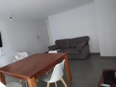 a living room with a wooden table and a couch at Departamento céntrico amplio in Río Cuarto