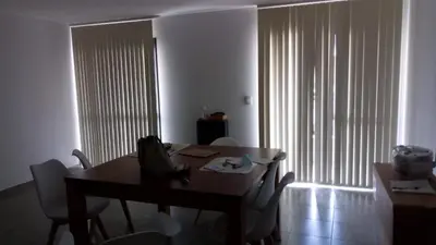 a dining room with a table and chairs and a large window at Departamento céntrico amplio in Río Cuarto