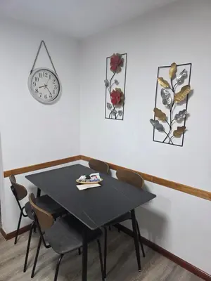 a table with chairs and a clock on a wall at Apartamento Los Capuchinos in Cordoba