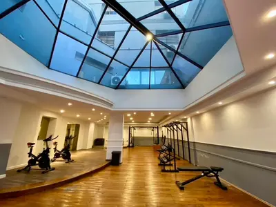 a gym with a glass ceiling with treadmills and exercise bikes at Estudio Lino in Cordoba
