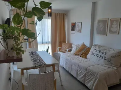 a living room with a couch and a table at Hermoso Departamento en Güemes sobre Cañada in Cordoba