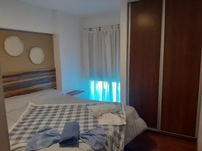 a bedroom with a bed with a blue shirt on it at Hermoso Departamento en Güemes sobre Cañada in Cordoba