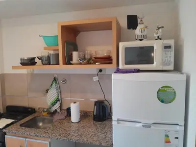 a microwave on top of a refrigerator in a kitchen at Hermoso Departamento en Güemes sobre Cañada in Cordoba