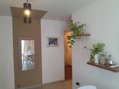 a hallway with a mirror and a dining room with a table at Hermoso Departamento en Güemes sobre Cañada in Cordoba