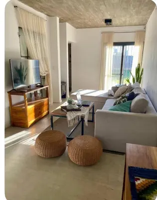 a living room with a couch and two ottomans at Casa de huésped in Río Tercero