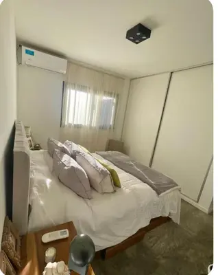 a bedroom with a bed with pillows and a table at Casa de huésped in Río Tercero