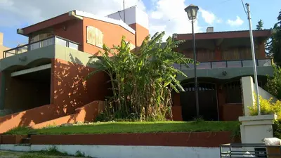 a building with a tree in front of it at Casa Villa Carlos Paz in Villa Carlos Paz