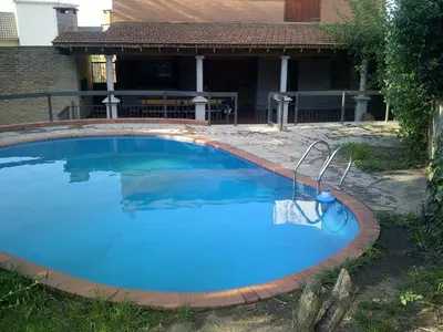 a large swimming pool in a yard next to a house at Casa Villa Carlos Paz in Villa Carlos Paz