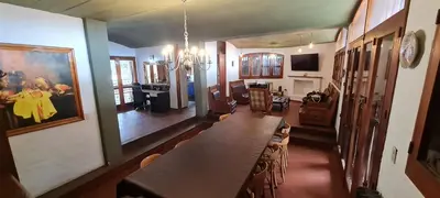 a dining room with a long table and a living room at Casa Villa Carlos Paz in Villa Carlos Paz