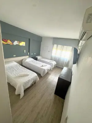 a room with two beds and a window in it at Hotel Nuevo Uruguay in Villa Carlos Paz