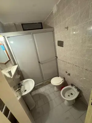 a bathroom with a toilet and a sink at Hotel Nuevo Uruguay in Villa Carlos Paz
