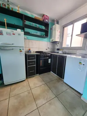 a kitchen with white appliances and black cabinets at General Paz KT I 7 in Cordoba