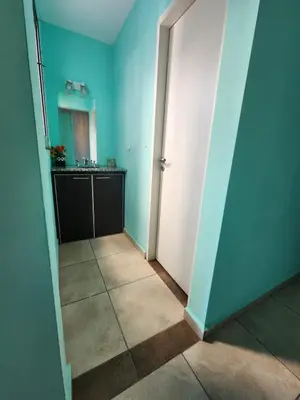a hallway with blue walls and a bathroom with a sink at General Paz KT I 7 in Cordoba