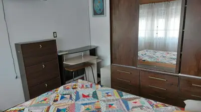 a bedroom with a bed and a dresser and a mirror at Casa a 800 mts de pleno centro - NO RECIBO GRUPO DE JOVENES in Villa Carlos Paz