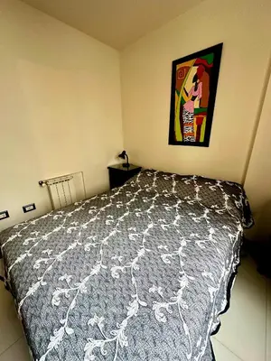 a bedroom with a bed and a picture on the wall at Depto Céntrico, Cochera, Pile, Terraza in Villa Carlos Paz