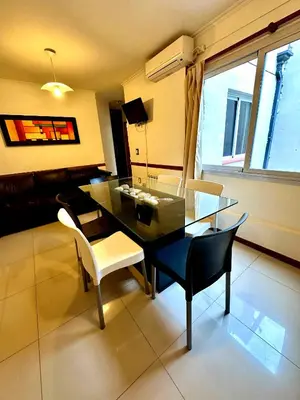 a dining room with a glass table and chairs at Depto Céntrico, Cochera, Pile, Terraza in Villa Carlos Paz