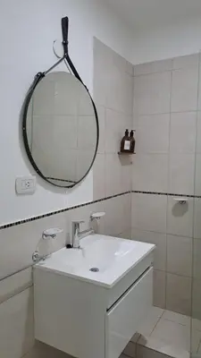 a white bathroom with a sink and a mirror at Vissia Vcp in Villa Carlos Paz