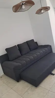 a black couch sitting in a room with two lights at Vissia Vcp in Villa Carlos Paz