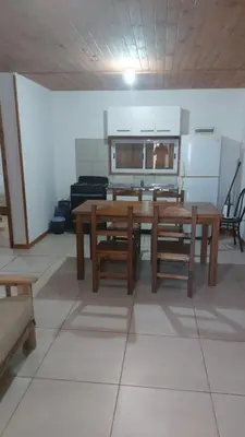 a kitchen with wooden tables and benches in a room at Abuelo José Cabaña Serrana in Villa Yacanto