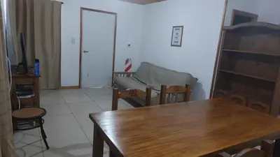 a living room with a table and a chair at Abuelo José Cabaña Serrana in Villa Yacanto