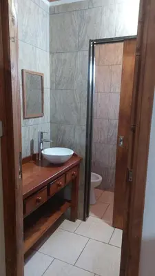 a bathroom with a sink and a shower with a toilet at Abuelo José Cabaña Serrana in Villa Yacanto