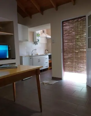 a kitchen with a table and a door to a kitchen at Ipomeas in Villa Rumipal