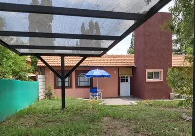 a blue umbrella in front of a house at Ipomeas in Villa Rumipal