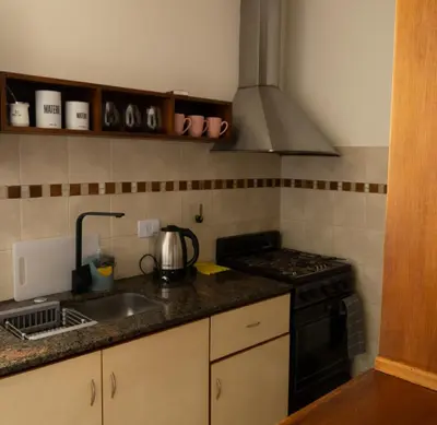 a kitchen with a sink and a stove top oven at Waru - Vista increíble y ubicación ideal in Cordoba