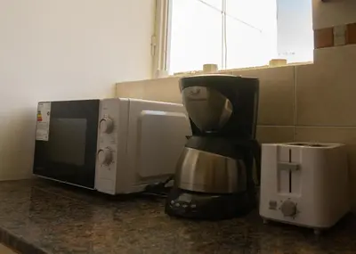 a coffee maker is sitting next to a microwave at Waru - Vista increíble y ubicación ideal in Cordoba