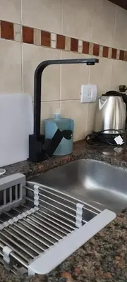 a kitchen counter top with a sink and aainer at Waru - Vista increíble y ubicación ideal in Cordoba