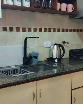 a kitchen counter with a sink and a tea kettle at Waru - Vista increíble y ubicación ideal in Cordoba