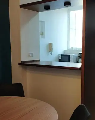 a kitchen with a counter with a microwave and a window at Waru - Vista increíble y ubicación ideal in Cordoba
