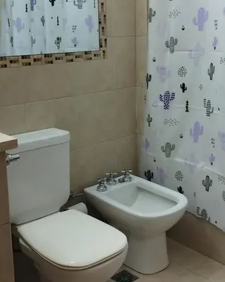 a bathroom with a toilet and a sink and a shower curtain at Waru - Vista increíble y ubicación ideal in Cordoba