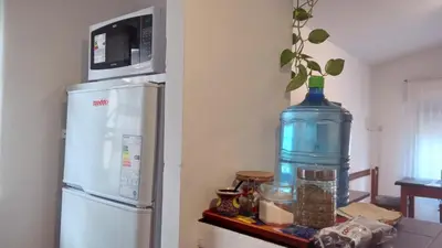 a large bottle of water sitting next to a refrigerator at Hospedaje La Dorita in Villa Carlos Paz