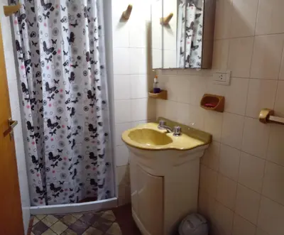 a bathroom with a sink and a shower curtain at Hospedaje La Dorita in Villa Carlos Paz
