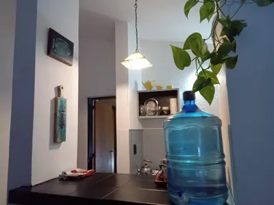 a large blue bottle sitting on a table with a plant at Hospedaje La Dorita in Villa Carlos Paz