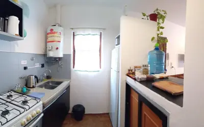 a kitchen with a stove and a sink and a refrigerator at Hospedaje La Dorita in Villa Carlos Paz