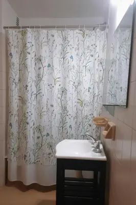 a bathroom with a shower curtain and a sink at Departamento funcional in Villa Carlos Paz