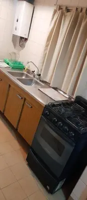 a kitchen with a stove and a sink at Departamento funcional in Villa Carlos Paz