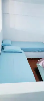 two twin beds in a room with blue sheets at Departamento funcional in Villa Carlos Paz