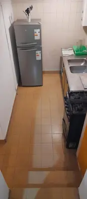 a small kitchen with a refrigerator and a sink at Departamento funcional in Villa Carlos Paz