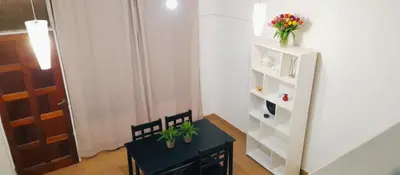 a room with a table and a shelf with flowers on it at Departamento funcional in Villa Carlos Paz