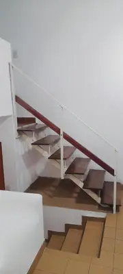 a staircase in a room with wooden risers at Departamento funcional in Villa Carlos Paz