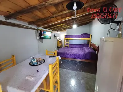 a room with a purple bed and a table at El Carpo in Santa Rosa de Calamuchita